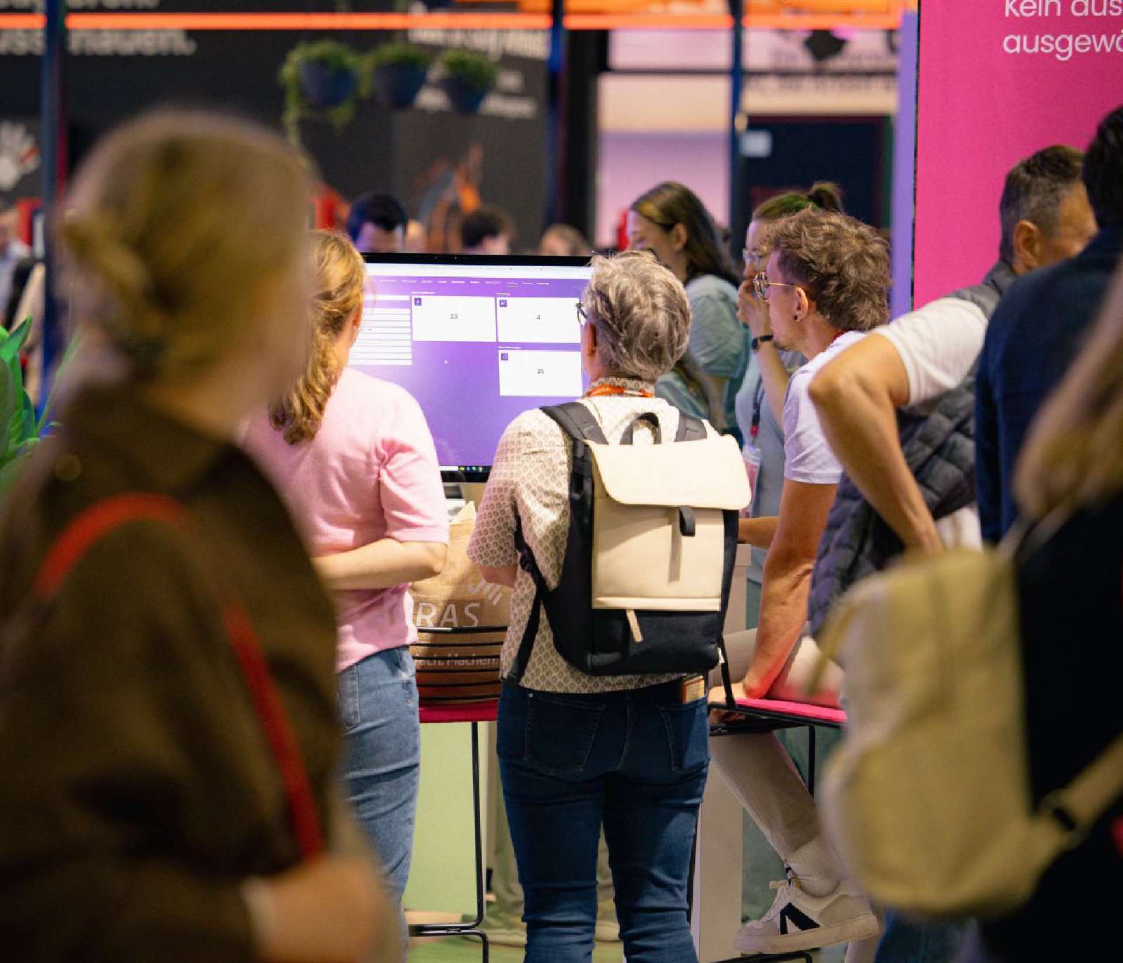 Besucher*innen am Perbility Stand vor einem Bildschirm mit der Software