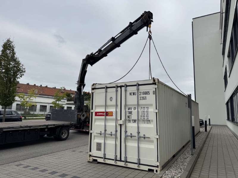 A container being unloaded by crane in front of our Bamberg office