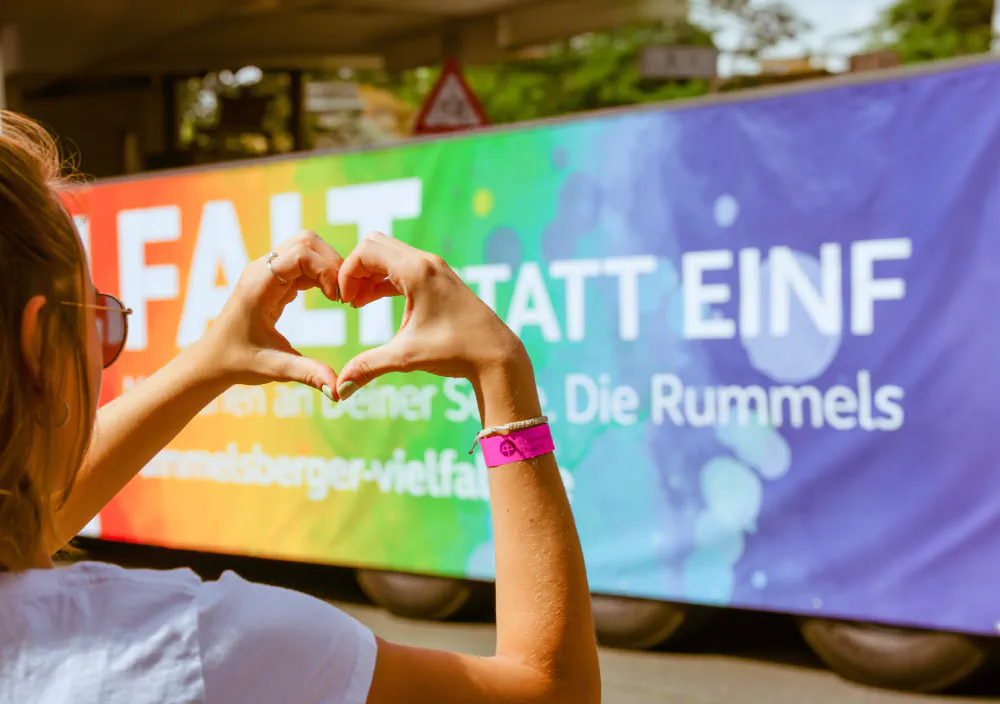 Zwei Hände formen ein Herz vor einem Banner der Rummelsberger Diakonie.